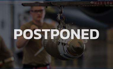 Image of the Fuze 2020 graphic with the word, "POSTPONED" overlayed on top of the image. The image is of a man standing in military khakis, wearing security goggles and working with a missile, which is hanging up. 