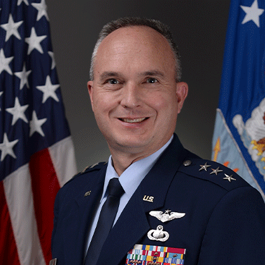 Picture of Lt. Gen. Eric Fick who is sitting in front of the American Flag